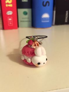 a keychain with a small animal on it sitting on a table next to some books