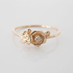 This mini rose flower ring is a beautiful little stacking ring that is like a little bouquet of gold roses and diamonds sitting on your finger. This ring is made in solid 14 karat gold with and set with a genuine VS-SI white diamond.Roses have long since represented love and romance, but are mainly known to represent God's love at work in the world. I made this ring as a reminder to us to always see the beauty and joy in the world.The simplicity of this ring stacks nicely with other rings and je Delicate Rose Gold Flower Ring, Dainty Flower Ring With Rose Cut Diamonds As Gift, Dainty Rose Jewelry For Anniversary, Dainty Rose Design Flower Ring For Anniversary, Dainty Rose Gold Stackable Promise Rings, Dainty Rose Detailed Jewelry For Anniversary, Dainty Rose Gold Diamond Flower Ring, Delicate Rose Gold Diamond Flower Ring, Delicate Rose Design Rose Gold Ring