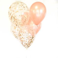 some pink and gold balloons in the shape of heart shaped balloons with confetti on them