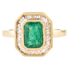 an emerald and diamond ring in yellow gold