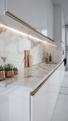 a kitchen with marble counter tops and gold accents