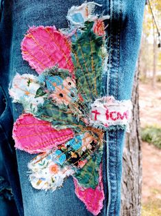 the jeans are decorated with flowers and leaves