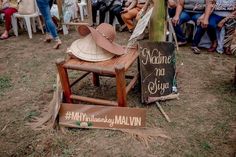 a group of people sitting in chairs around a tree with hats on top of it