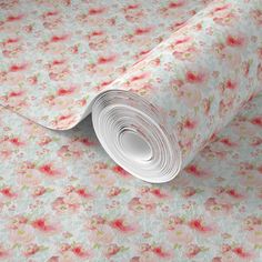 a roll of paper on top of a flowery wallpaper with pink and green flowers