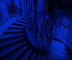 a spiral staircase in a building with blue lighting