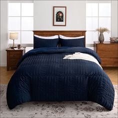 a bed with blue comforter and pillows in a room