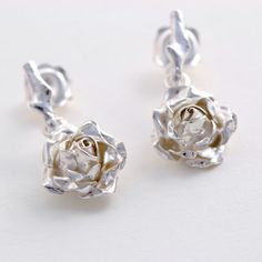 Silver Rose Earrings, Rose Stud Earrings, Flower Drop Earrings Dainty handmade rose earrings with a small open rose suspended by a delicate rose thorns stud. * Material: Sterling Silver * Size of Rose: Approx. 2.5cm (1in) long & 1cm (0.4in) diameter * Earring Type: Stud Earrings with butterfly back * Ready to Ship in 2-3 business day * Made in the United Kingdom PACKAGING: Comes uniquely packaged in my Magnolia Restrepo Style Case as shown in the last photo. Additional, I gift wrap all my bo Wedding Jewelry With Roses In Sterling Silver, Wedding Jewelry In Sterling Silver With Roses, Formal Rose Earrings With Rose Design, Formal Rose-design Rose Earrings, Elegant Rose Sterling Silver Earrings, Elegant Rose Colored Sterling Silver Earrings, Rose Gold Rose Detail Wedding Earrings, Rose Dangle Flower Earrings For Wedding, Rose Colored Dangle Flower Earrings For Wedding