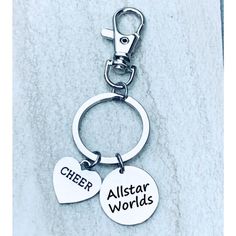 two heart shaped key chains with the words cheer allstar world on them