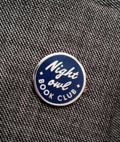 a blue and white pin with the words nights park book club on it's back