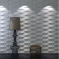 a lamp sitting on top of a wooden table next to a wall covered in white bricks