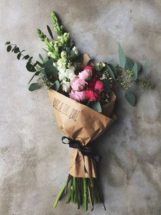 a bouquet of flowers wrapped in brown paper