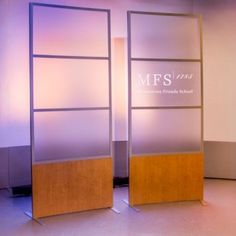 an empty room with two tall glass partitions in front of the wall and purple lighting behind it