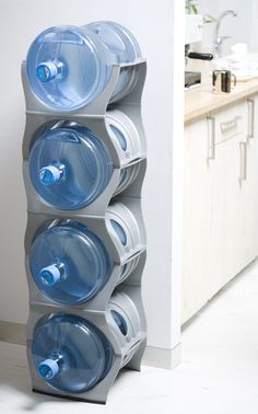 three plastic water bottles are stacked on top of each other in a room with white walls