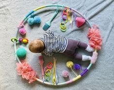 a baby doll laying on top of a circle of hair clips and other items around it