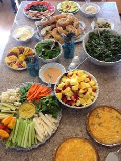 a table topped with bowls filled with different types of food next to pies and dips