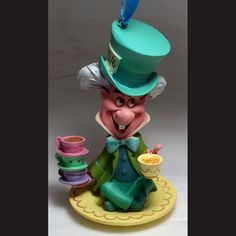 a figurine that is wearing a top hat and holding a cup in its hand