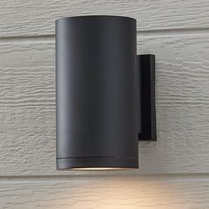 a black light mounted on the side of a white wall next to a lamp shade