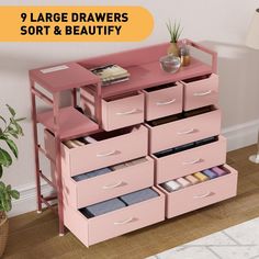 a pink dresser with drawers and some plants