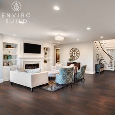 a living room filled with furniture and a fire place next to a stair case on the wall