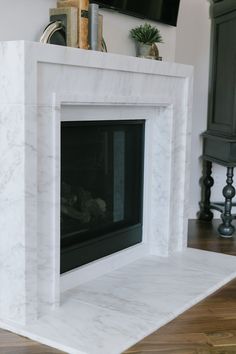 a white marble fireplace in a living room