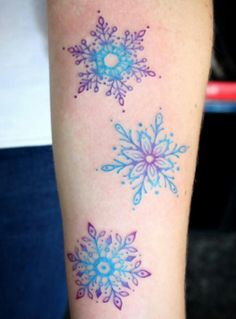 snowflakes are on the arm of a woman