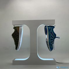 two pairs of shoes are on display in an acrylic case, one is green and the other is blue