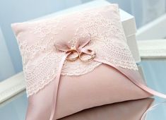 a pink ring pillow with lace on it