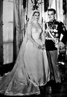 an old black and white photo of a man and woman in formal dress standing next to each other