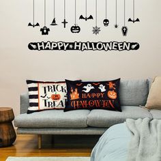 a living room filled with furniture and halloween decorations on the wall next to a couch