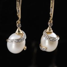 These elegant dangle earrings feature lustrous pearls wrapped in sparkling diamonds, set in 14k yellow gold. The sophisticated design combines the classic beauty of pearls with the dazzling brilliance of diamonds, creating a stunning visual contrast. Perfect for adding a touch of luxury and refinement to any outfit, these earrings are a timeless accessory that exudes grace and elegance. Metal Type:  14K Yellow Gold  Weight: 4.7G Length: 16.25mm per earring Width: 8.94mm per earring Gem: Pearl Quantity:2 Shape: Oval Dimensions: Aprox 10.5x9.2mm Gem: Diamond Quantity: 18 Cut: Single Cut Round Carat: Aprox 0.13ctw Back Type: lEVER bACK Hallmarks: 14K ; B We look forward to providing you with an exceptional experience and helping you find more exquisite additions to your collection. *More Pict Luxury Pear-shaped Diamond Evening Earrings, Pear-shaped Evening Diamond Earrings, Luxury Diamond Earrings With Pearl Drop, Evening Fine Jewelry Pear-shaped Diamond Earrings, Pear-shaped Diamond Earrings With Accents For Evening, Elegant Pear-shaped Diamond Earrings For Evening, Classic Diamond Accented Earrings For Evening, Luxury Pearl Earrings With Diamond Accents For Evening, Fine Jewelry Earrings With High Luster For Evening