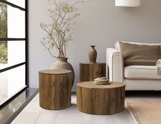 a living room filled with furniture and a vase on top of a wooden table next to a window