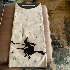 an oven mitt with a witch silhouette on it