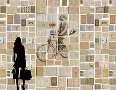 a woman standing in front of a wall covered with old books