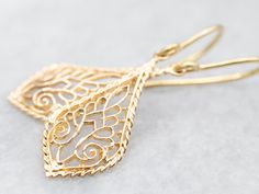 These stunning earrings add a touch of elegance to any outfit. Made with yellow gold, the intricate filigree design showcases expert craftsmanship. With their elegant drop shape, these earrings are perfect for any occasion. Elevate your style with these timeless and sophisticated earrings! Metal: 14K Yellow Gold Measurements: 11 x 37 mm SKU #: A43131 Each piece has been identified and graded by a Graduate Gemologist who has been certified by the Gemological Institute of America (GIA). We have six brick-and-mortar storefronts in Maine, Massachusetts, and New Hampshire and have been in business for over 25 years! Please visit our Shop's About Page or our website for more information about our jewelry. For questions about diamond grading, we recommend the  Gemological Institute of America (GI Sophisticated Earrings, Gold Dangle Earrings, Earrings Metal, Filigree Design, Stunning Earrings, Gold Earrings Dangle, Showcase Design, Wedding Shop, Anniversary Gift