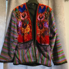 Vintage Guatemalan Art To Wear Boho Embroidered Velvet Jacket L. Front Panels In Red Velvet With Embroidered Flowers And Birds. Purple Panel Above Pockets With Metallic Threading. 2 Big Front Pockets, Back Is Striped. Very Colorful. Excellent Condition. Fits Up To A Large, Can Be Work Oversize. 42" Bust, 29" Long, 25" Sleeves Fall Long Sleeve Outerwear With Embroidered Border, Red Folk Style Spring Outerwear, Traditional Fall Outerwear With Embroidered Border, Traditional Outerwear With Embroidered Border For Fall, Fall Multicolor Outerwear With Floral Embroidery, Multicolor Geometric Embroidered Outerwear For Fall, Bohemian Long Sleeve Outerwear With Embroidered Border, Fall Multicolor Outerwear With Geometric Embroidery, Traditional Embroidered Border Outerwear For Fall