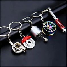 four different types of key chains with various items attached to them on top of a black surface