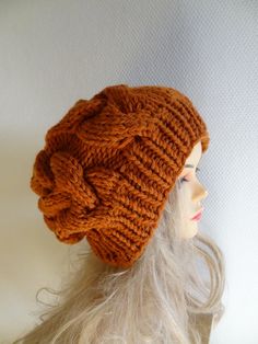 an orange knitted hat on top of a mannequin's head with long white hair