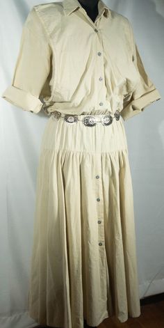 We adore this country pure cotton tan khaki maxi dress! This is a craft folksy 80s vintage dress that has a 1980's made in U.S.A. Ansley designer collectible label. This dress has a prairie western look with a half sleeve, blouse and V neckline top portion, a slightly stretchy elastic high waist, and an A line skirt lower half with buttons down the front. The 80s cut and style is unique with a built in front vest that's baggy to blouse over a drop waist yoke panel to the bottom A line skirt swin Solid Color Vintage Cotton Dress, Vintage Beige Midi Dress For Fall, Beige Buttoned Maxi Dress For Summer, Solid Color Vintage Summer Dress, Summer Beige Maxi Dress With Buttons, Vintage Beige Maxi Dress, Vintage Maxi Dress With Buttons For Summer, Vintage Summer Maxi Dress With Buttons, Vintage Beige Short Sleeve Maxi Dress