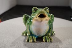 a ceramic frog sitting on top of a table