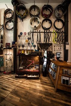 a room filled with lots of different types of clocks hanging on the wall and wooden floors