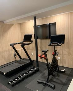 there are two exercise bikes and a laptop on the treadmill in this home gym