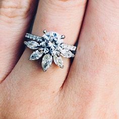 a woman's hand with a diamond ring on top of her finger and an engagement band