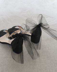 a pair of black shoes with bows on them