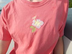 a girl wearing a pink shirt with a flower on it