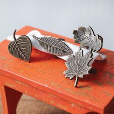 two metal leaves sitting on top of an orange table