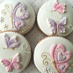 four decorated cupcakes sitting on top of a table