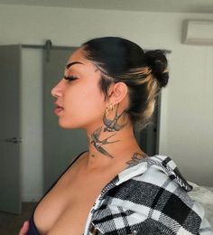 a woman with tattoos on her neck and chest