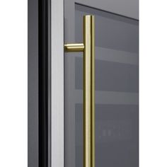 an open door with a gold handle on it's side and glass doors in the background