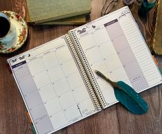 a desk with a notebook, pen and cup of coffee