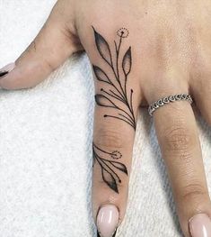 a woman's hand with a tattoo on it and a ring in the middle